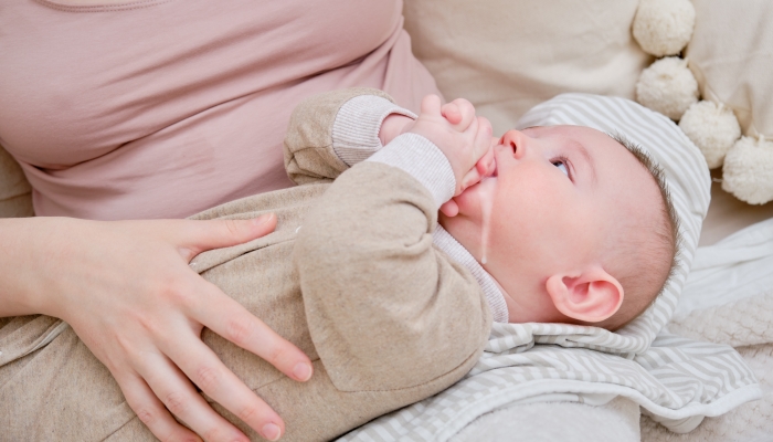 A Mother Woman Holds An Infant Baby To Regurgitate Excess Air After Breastfeeding